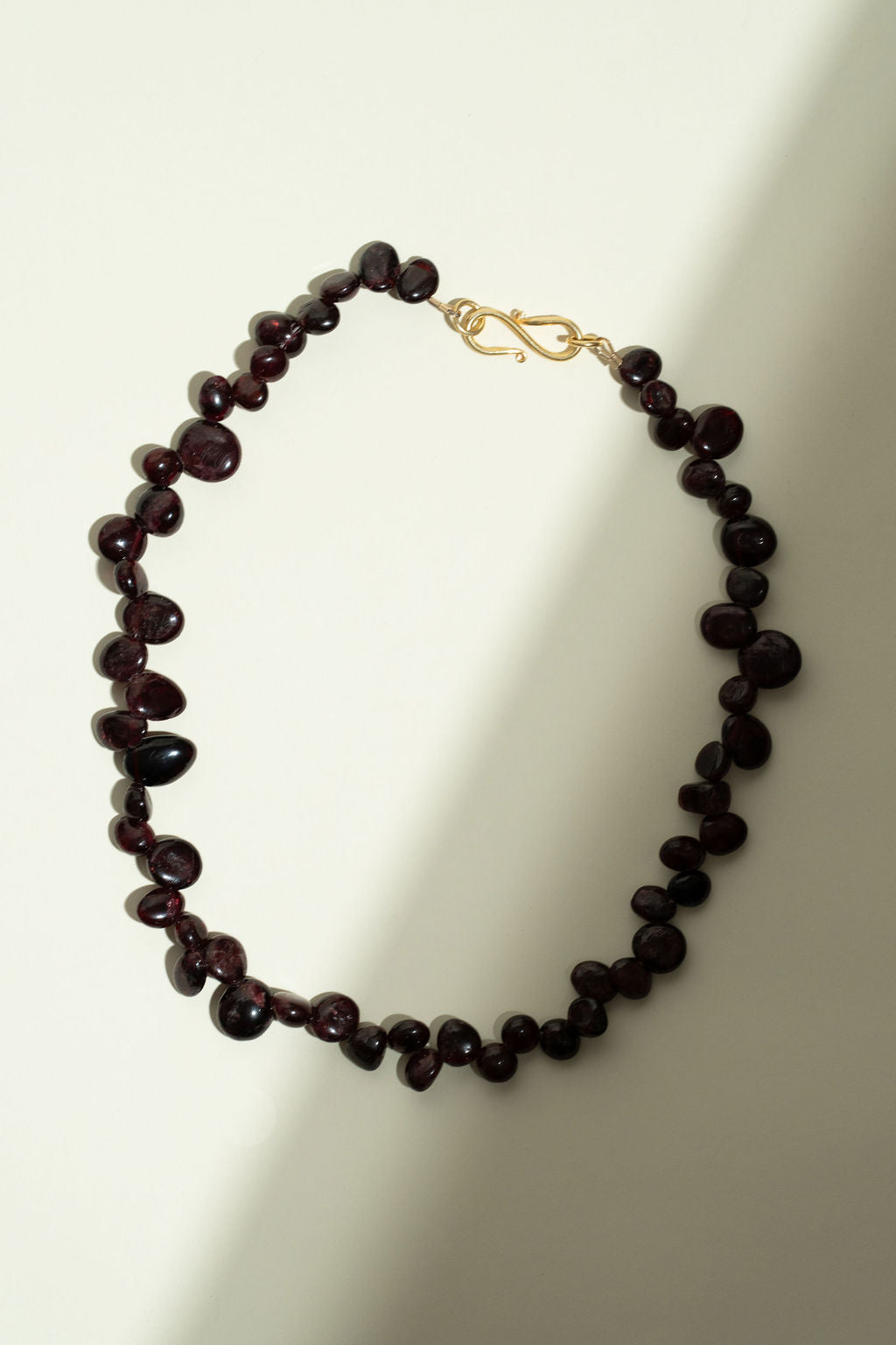 Necklace with garnet stone beads on a light background